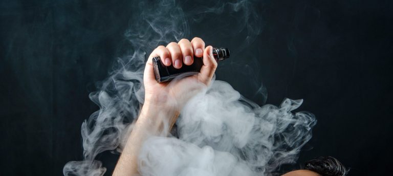 hand holding vape e-cigarette or electronic cigarette with white