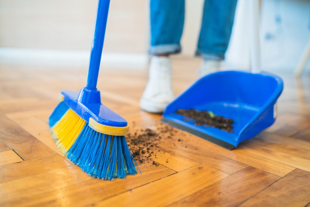 Portrait,Of,Young,Latin,Man,Sweeping,Wooden,Floor,With,Broom